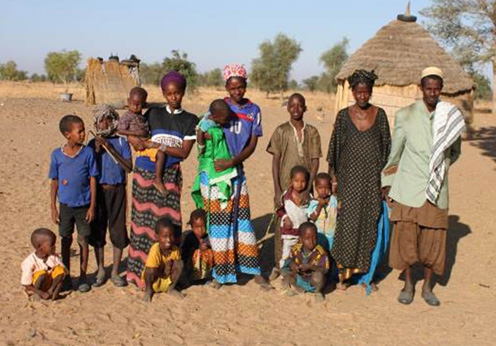 The family of a Fulani project farmer, who asked to be photographed in Touba. Fulani’s are very traditional and typically late adopters of new technologies. In the background is a typical house. Photo: Karen Marshall